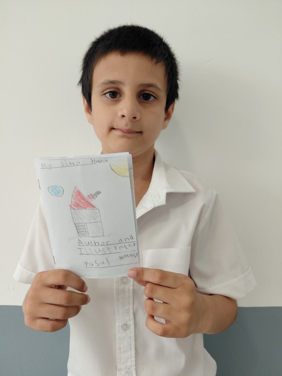 Learner holding a hand-drawn house booklet